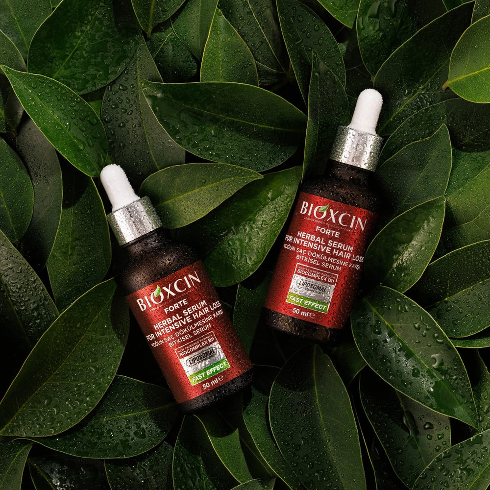 Two bottles of BIOXCIN herbal serum on green leaves
